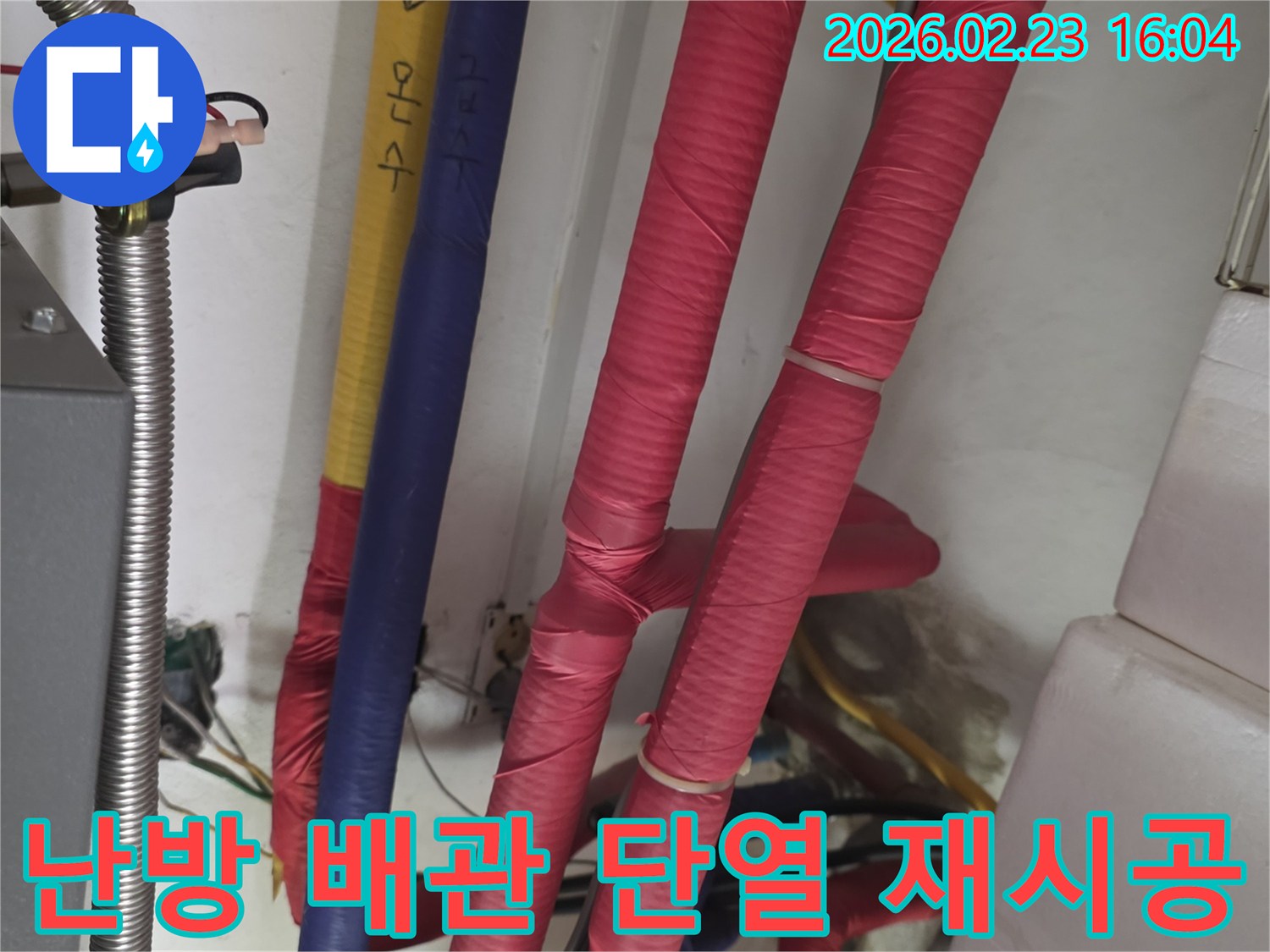 붉은색 단열재로 감싸진 난방 배관의 모습-단열재 재시공을 통한 난방 효율 증대 및 누수 점검