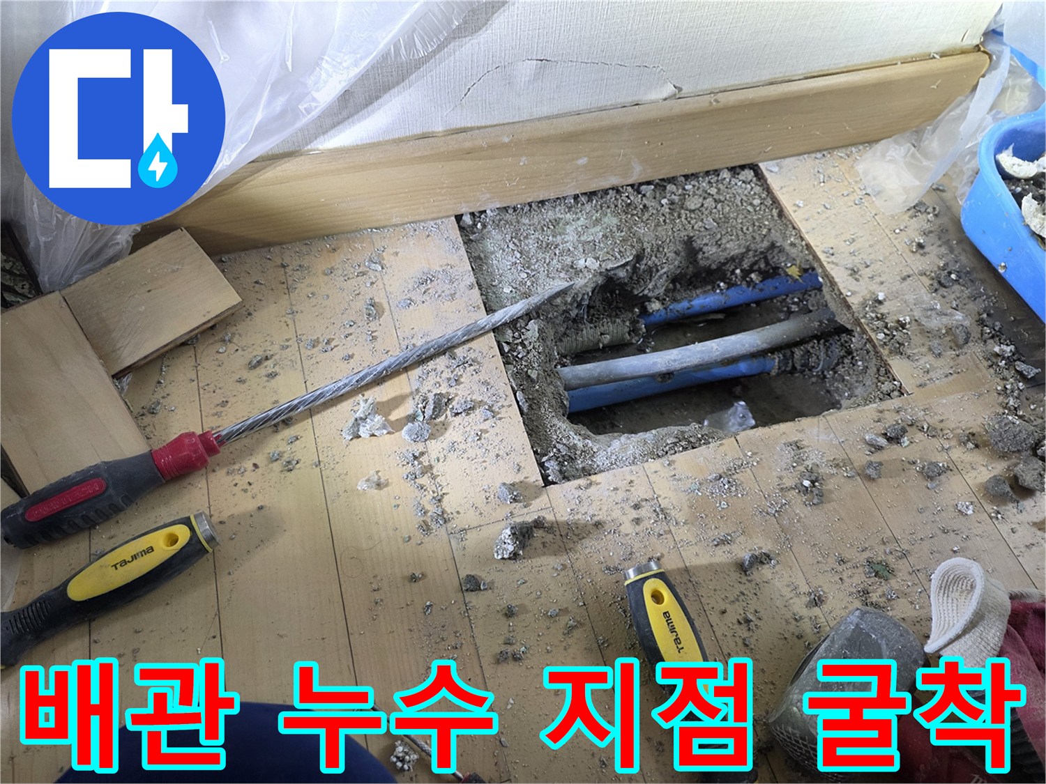 콘크리트 바닥을 파내어 노출시킨 파란색 난방 배관의 손상 부위