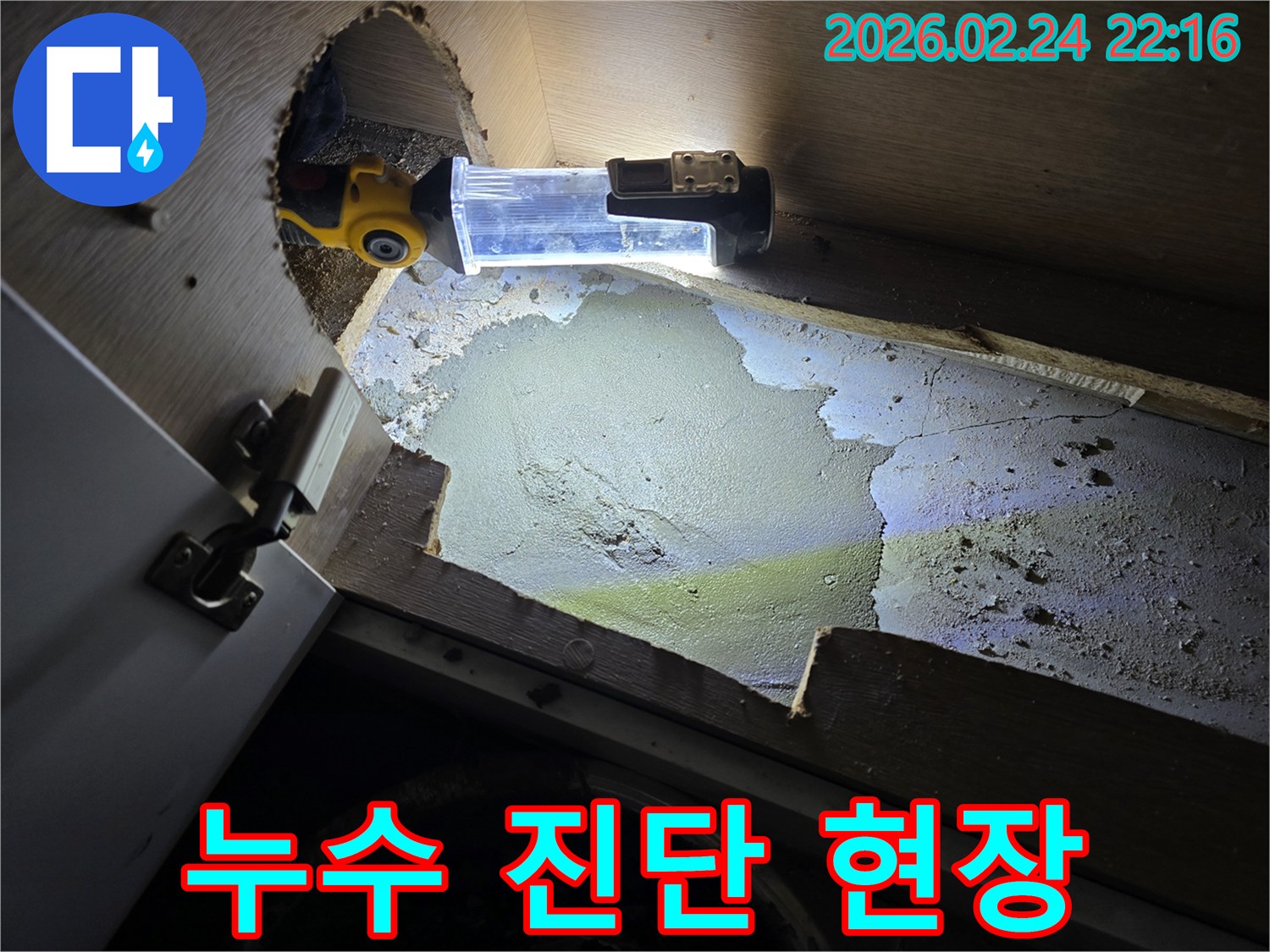 누수-엔지니어가-좁고-어두운-공간에서-누수-진단을-위해-조명-장비를-사용하여-정밀하게-살펴보는-모습