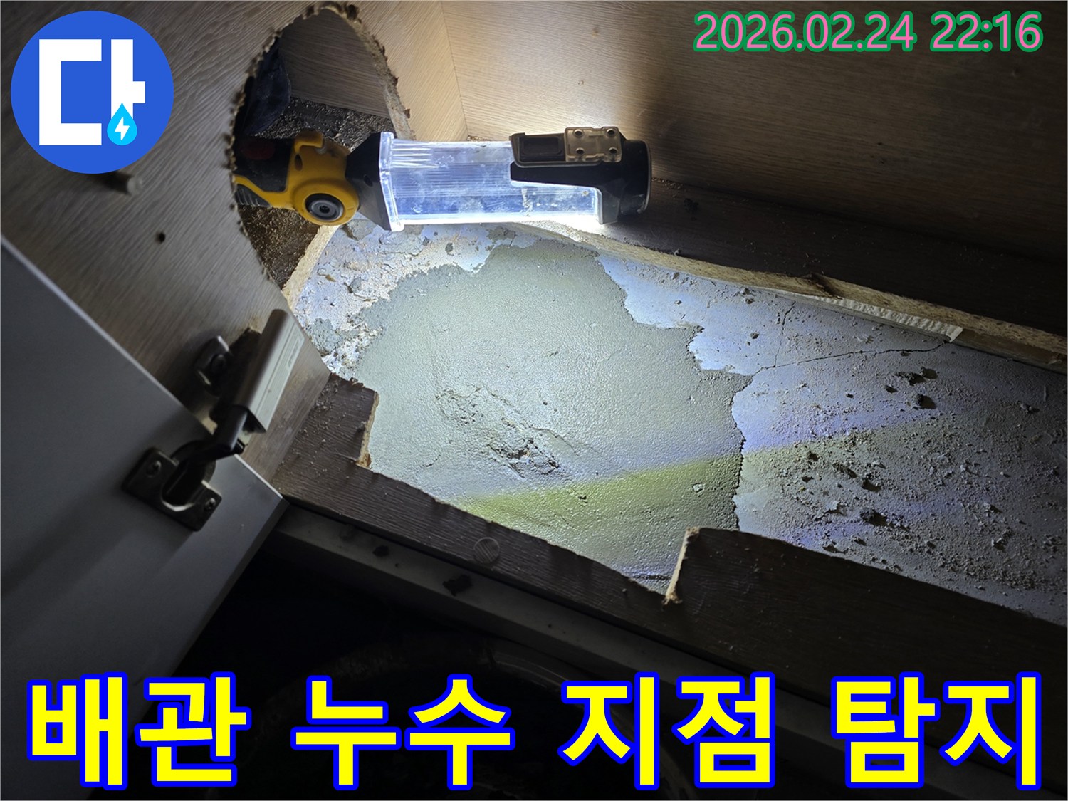 어두운-싱크대-하부에서-배관-누수-지점을-정확히-찾기-위해-조명-장비를-활용하는-누수-전문가
