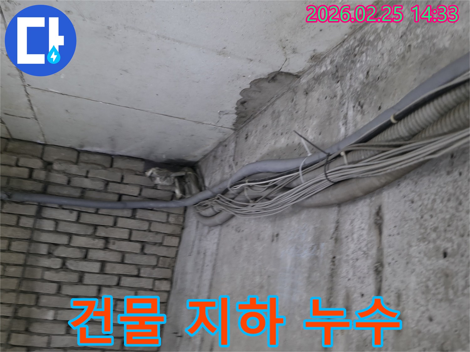 건물 지하의-콘크리트 벽과-벽돌 벽이 만나는-구석에서-발견된-오래된 물샘의-흔적과 주변 배관