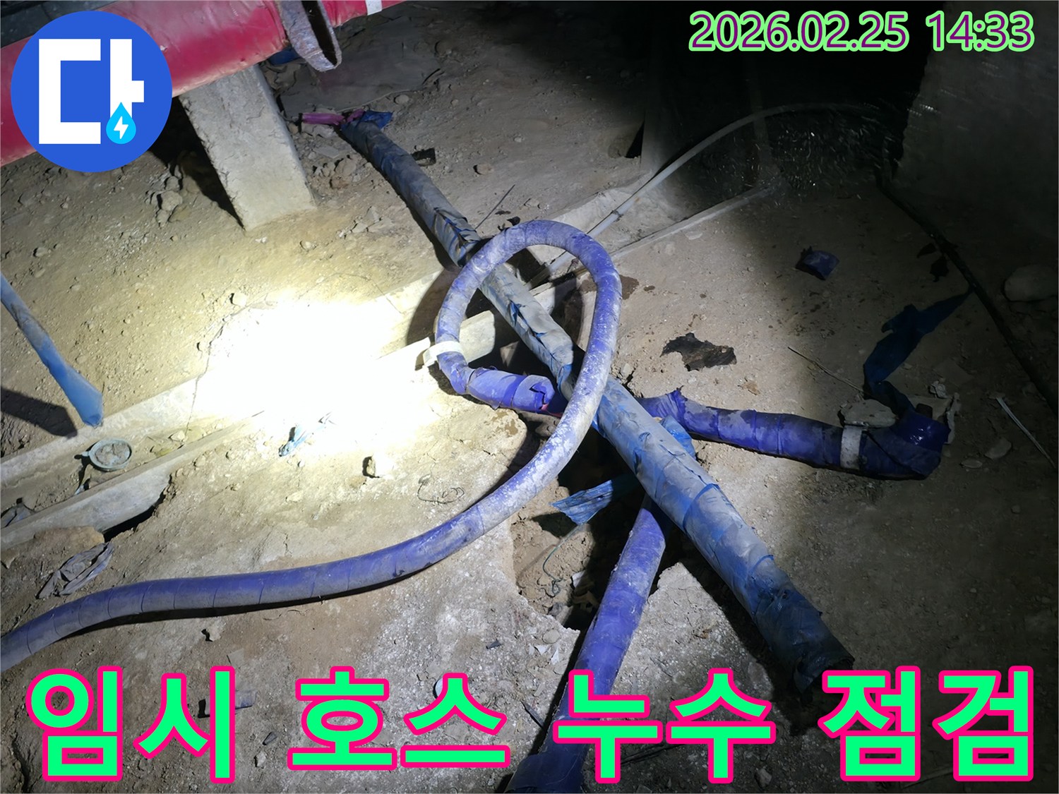 공사 현장에 설치된 임시 호스의-연결 부위에서 발생할 수 있는-누수를 꼼꼼하게 점검하고 보수하는 현장입니다