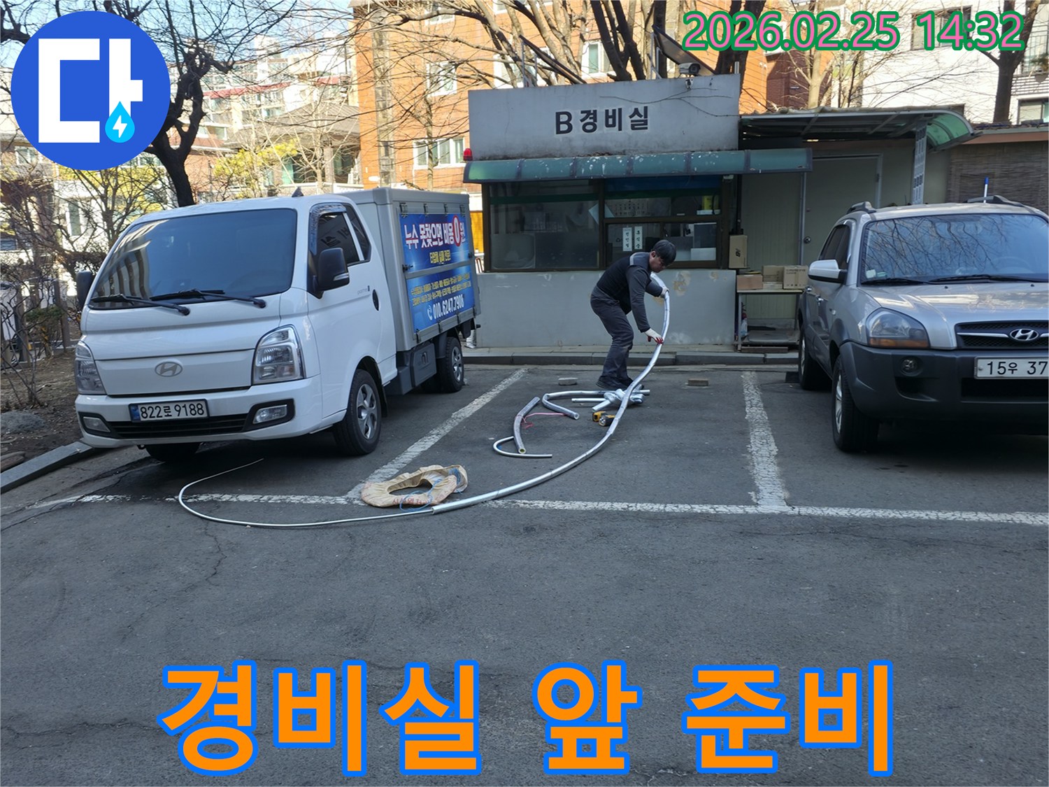 누수 전문 엔지니어가 공동주택 경비실 앞에서-누수 탐지 장비를 준비하며-정확한 원인 파악을 위해 노력하고 있습니다.