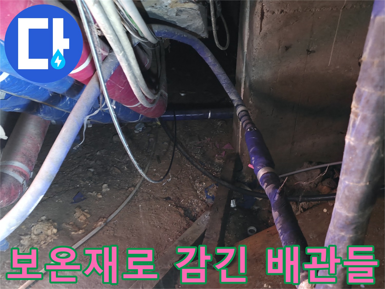 분홍색과 파란색 보온재가 씌워진 지하 배관 시설물