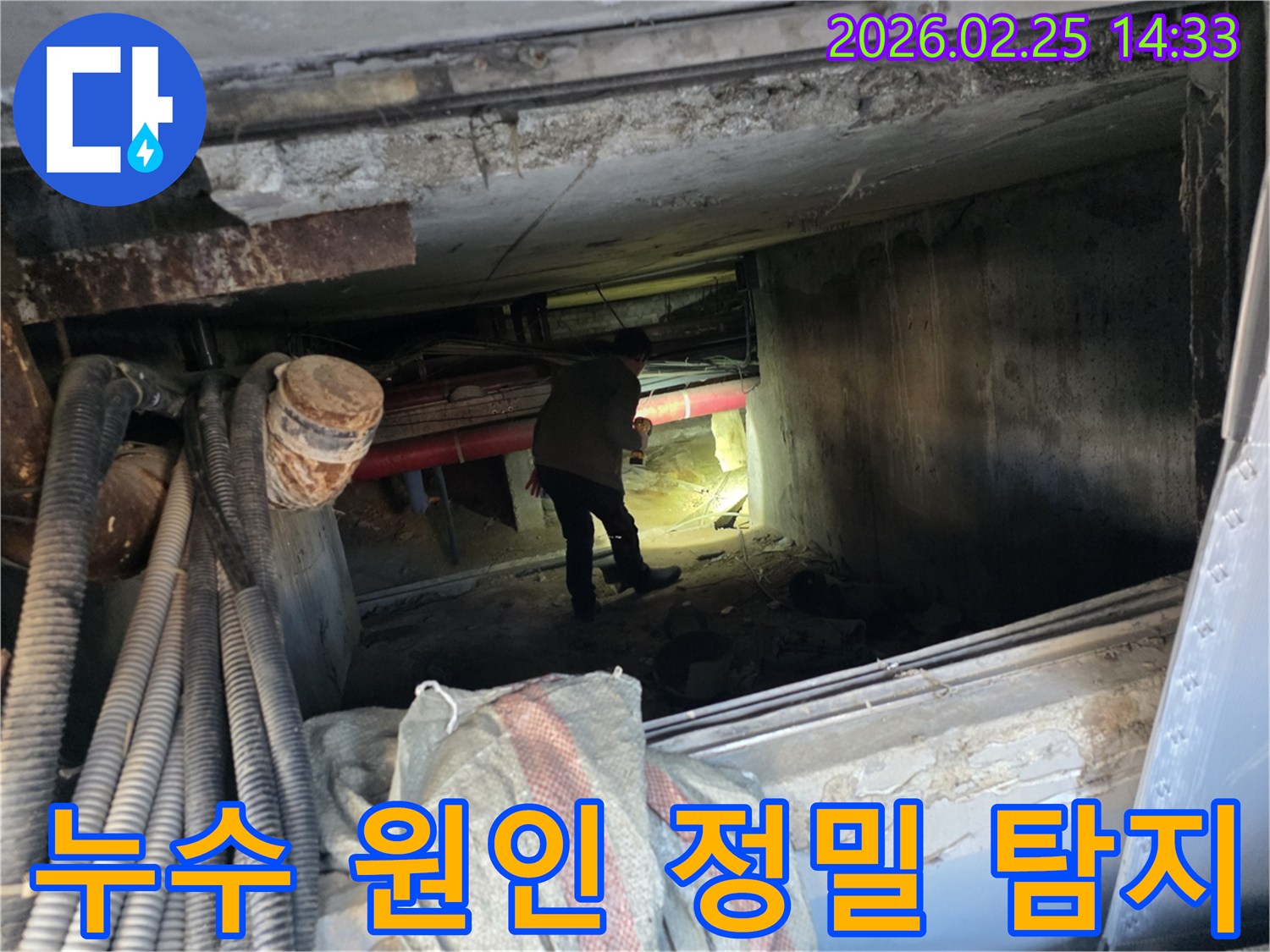 손전등을 든-누수 전문가가-복잡한 배관 사이에서-누수 지점을-확인하는 중