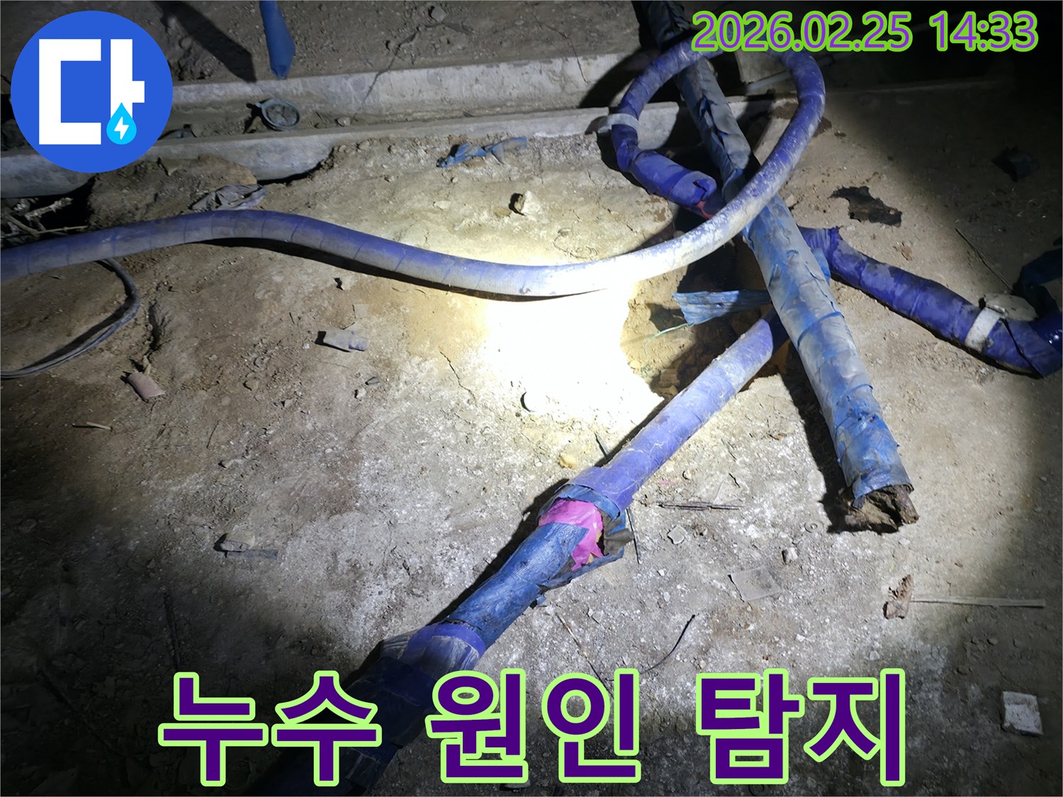 어두운 공간에서-누수 원인을 찾기 위해-배관을 정밀하게-점검하는 전문가의 모습입니다.