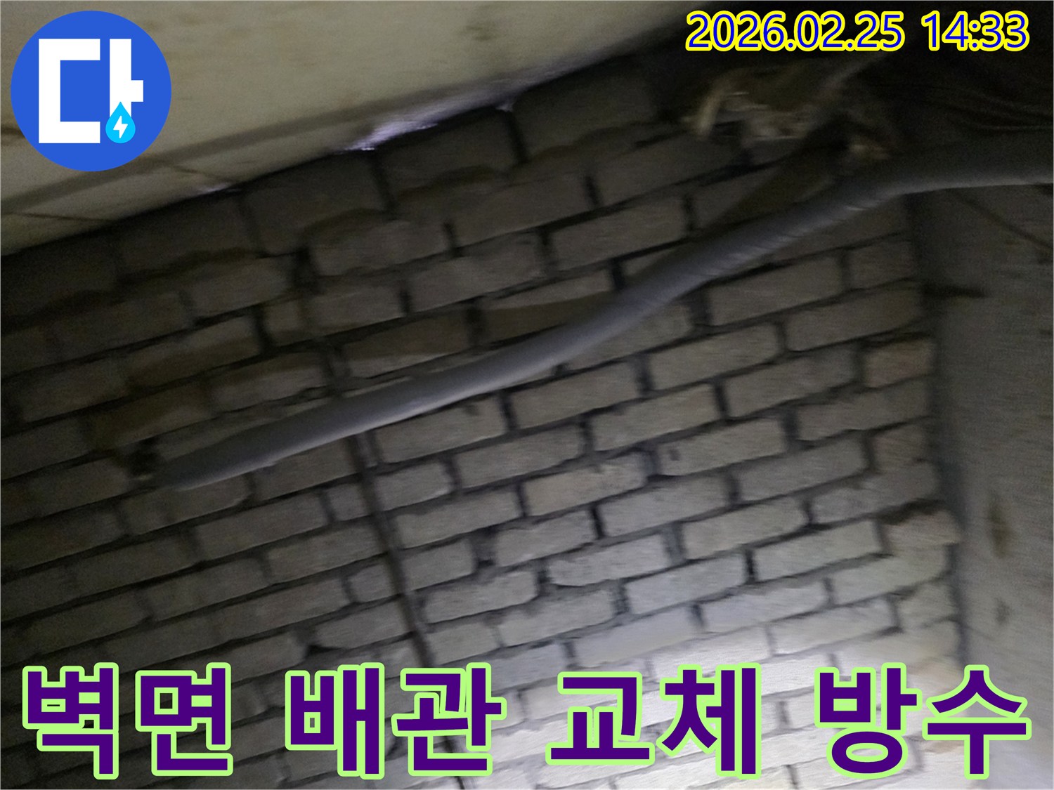 어두운 벽돌 벽면을 배경으로-낡은 배관을 교체하고-방수 작업을 준비하는-현장 공사 모습입니다.