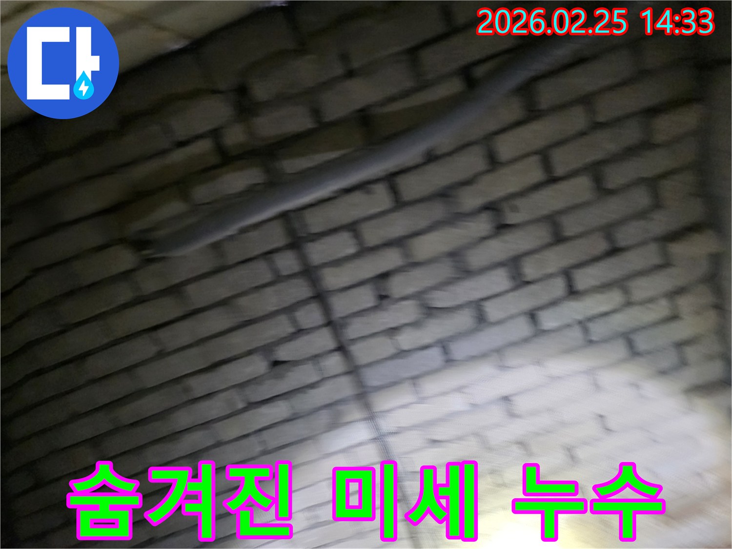 어두운-벽돌벽-내부에-숨겨진-배관에서-발생하는-육안으로-찾기-어려운-미세-누수를-정밀-장비로-탐지하는-전문가의-모습