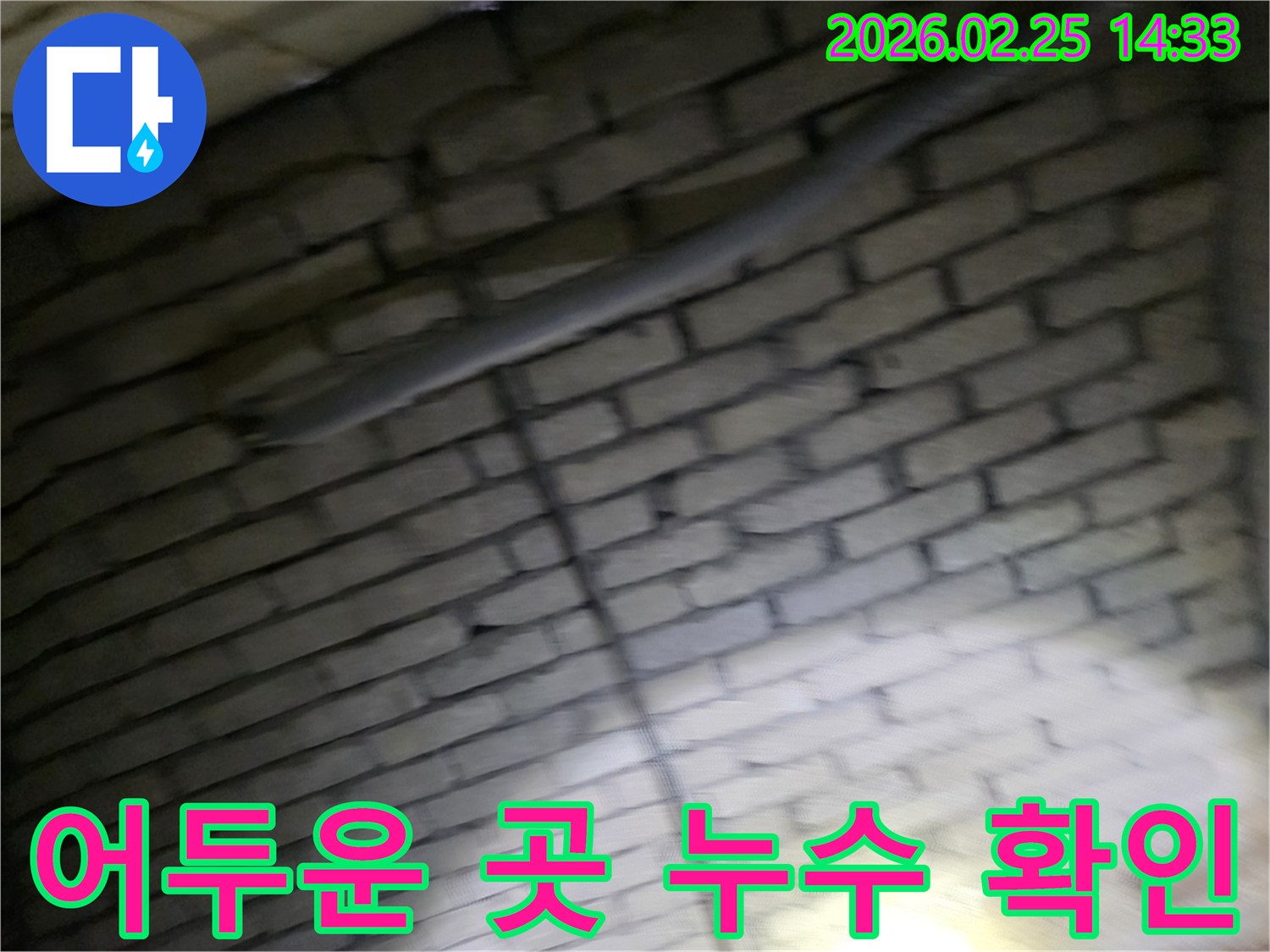 어두운-벽돌벽-내부에서-배관-누수를-확인하기-위해-전문가가-조명으로-비추며-정밀하게-점검하는-모습-육안으로-확인하기-어려운-누수-지점-탐지