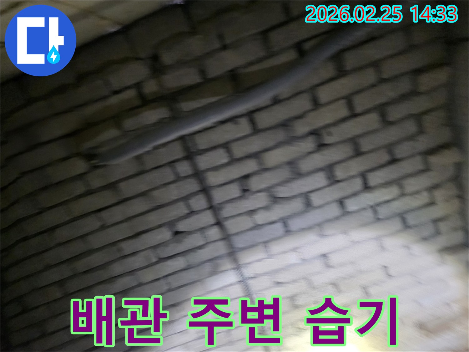 어두운-벽돌벽-내부의-배관-주변-환경을-점검하며-습기-발생-여부를-확인하고-관리하는-전문가의-모습