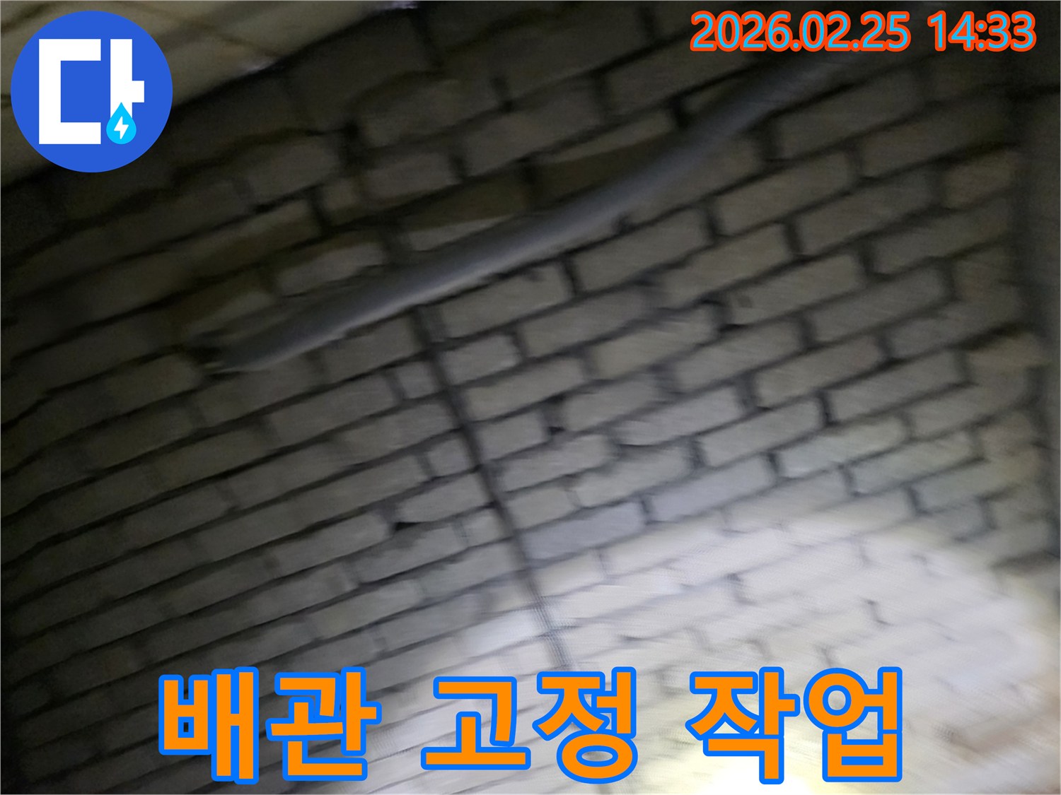 어두운-벽돌벽-내부의-배관을-안전하게-고정하여-누수-재발을-방지하고-안정성을-확보하는-전문가의-모습