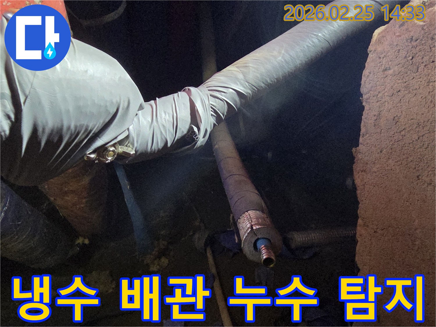 어두운 작업 공간에서-장갑을 낀 손이-냉수 배관의-누수 지점을-정밀하게 탐지하여-원인을 파악하는-모습입니다
