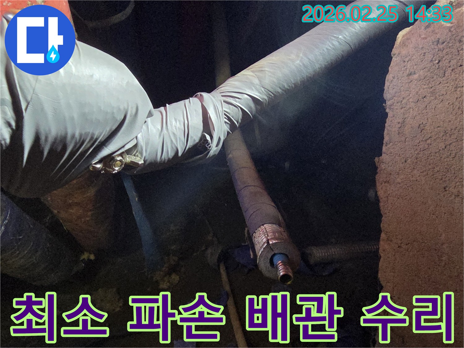 어두운 작업 공간에서-장갑을 낀 손이-최소한으로 노출된-배관의 누수 지점을-정교하게 수리하는-모습입니다