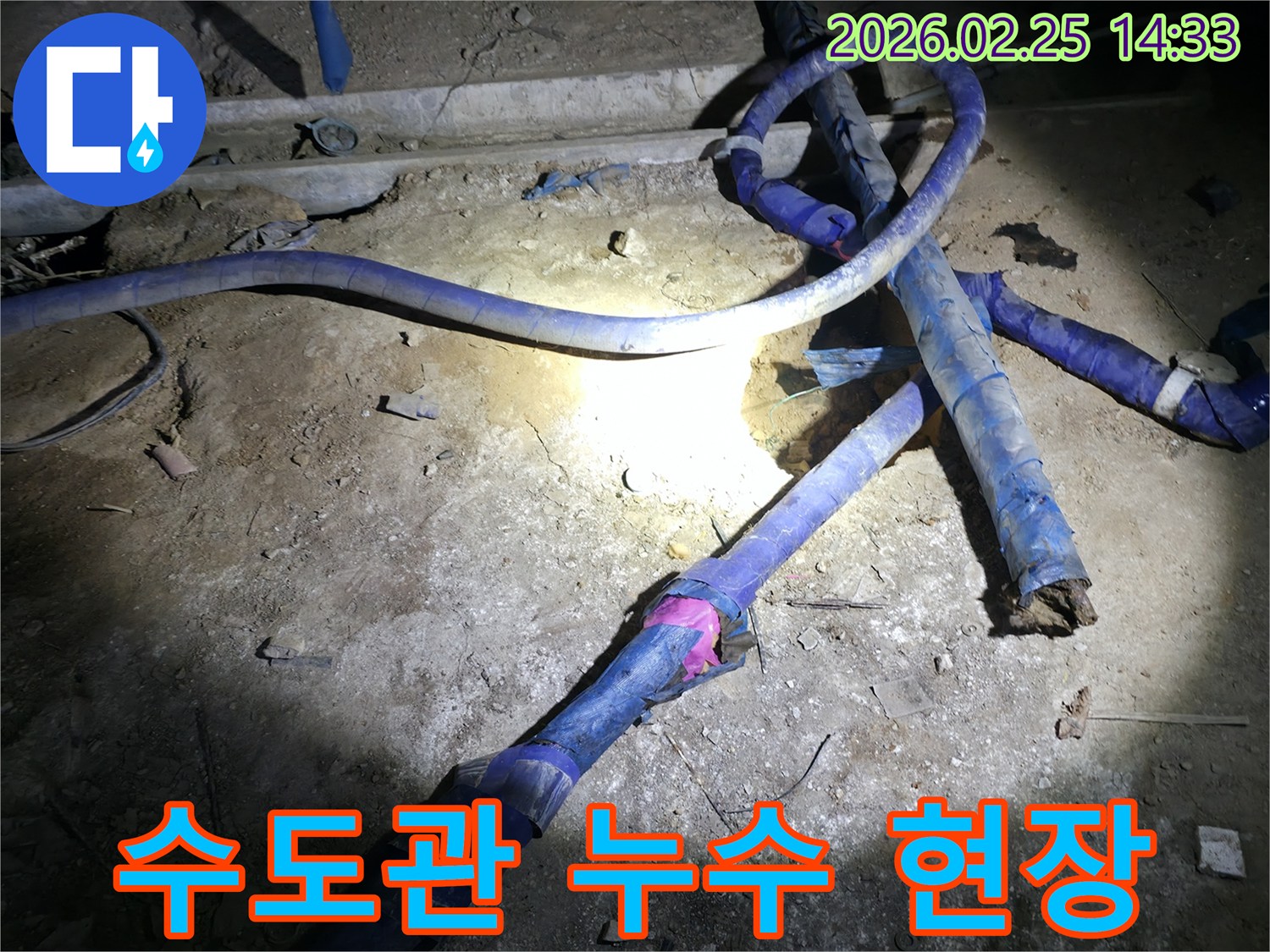 어두운 지하 공간에서-누수된 수도관을-전문가가 점검하는 모습입니다.