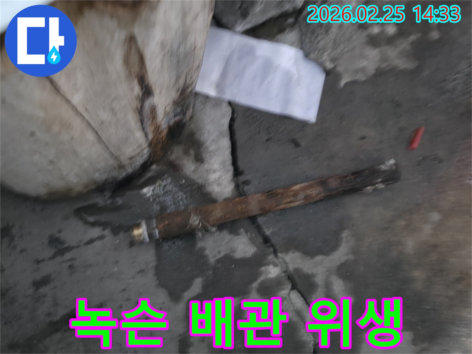 오래되어 녹슬고-부식된 배관이-젖은 바닥에 놓여있는-누수 공사 현장 사진입니다.