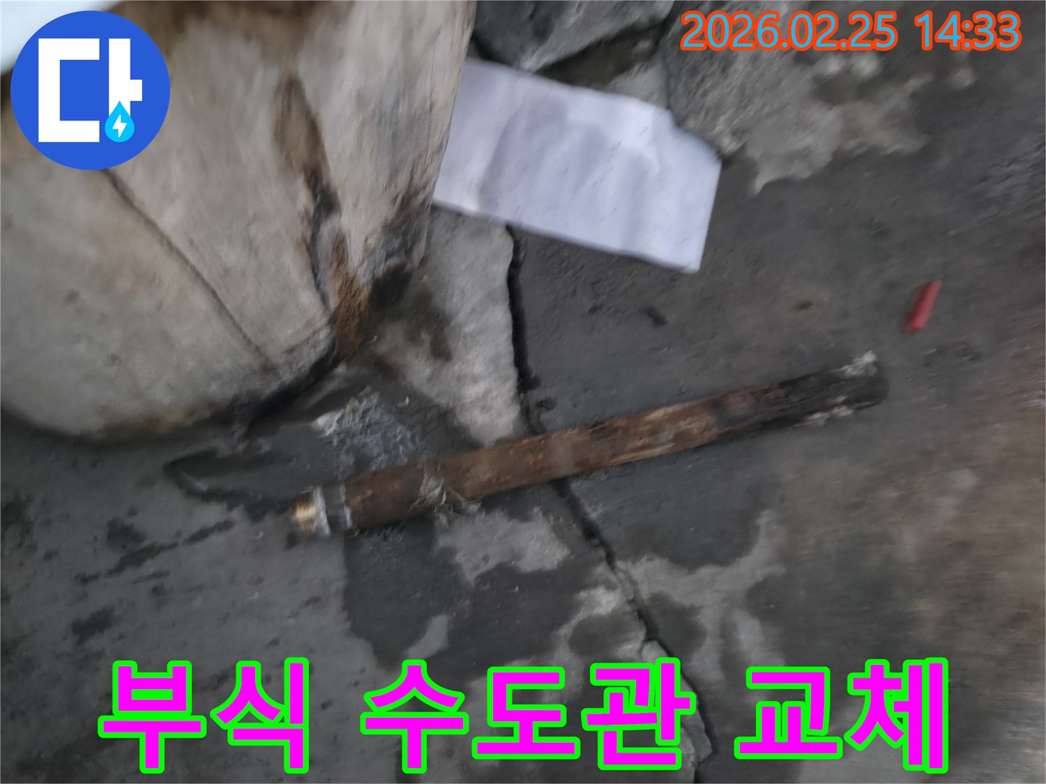 오래되어 부식된-파열된 수도관이-젖은 바닥에 놓여있는-누수 공사 현장 사진입니다.