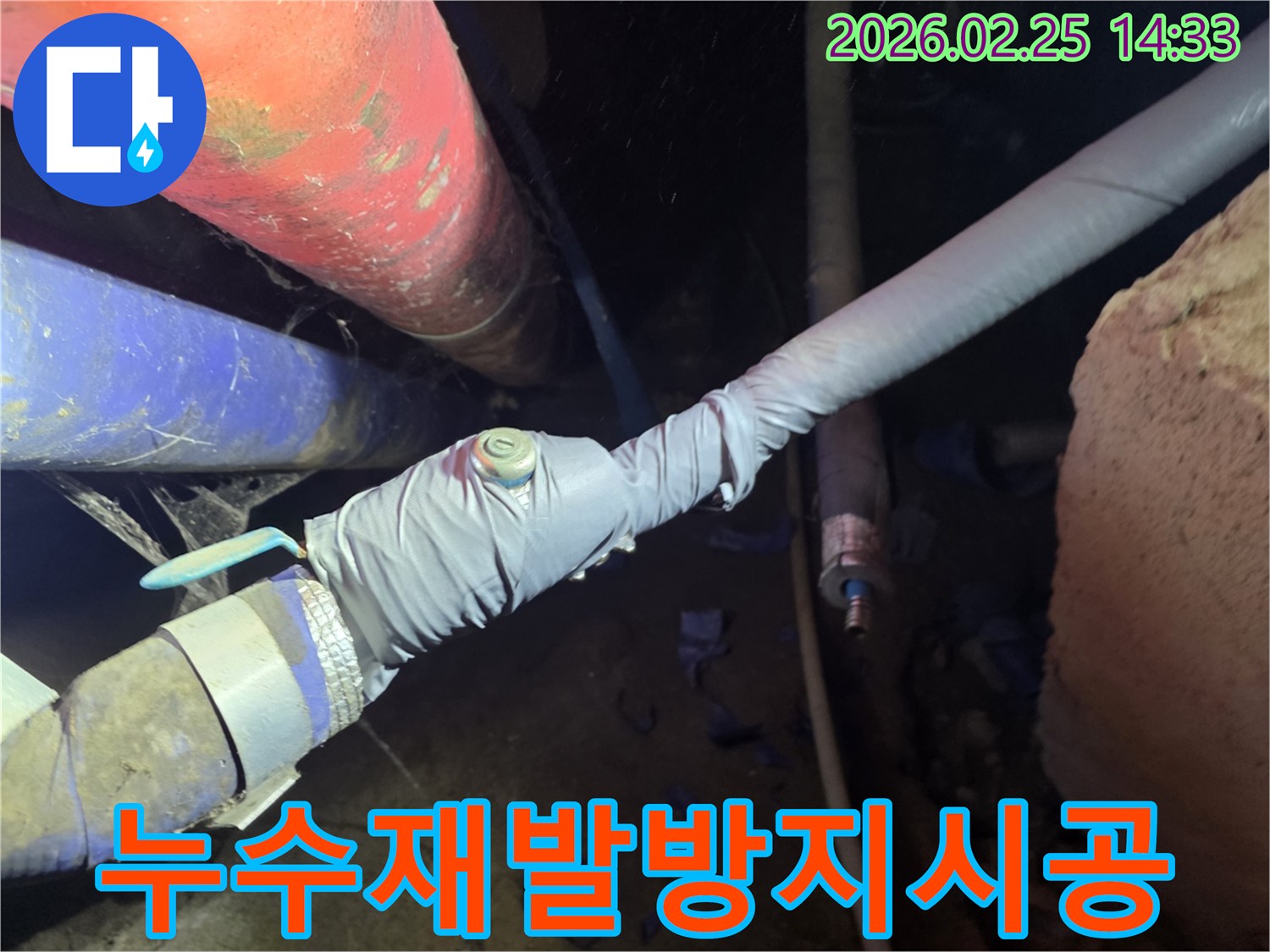 이 이미지는 누수 탐지를 위해 배관에 압력 측정 장비를 연결하는 전문 엔지니어의 모습을 보여줍니다-정확한 누수 지점을 찾기 위한 핵심 과정입니다