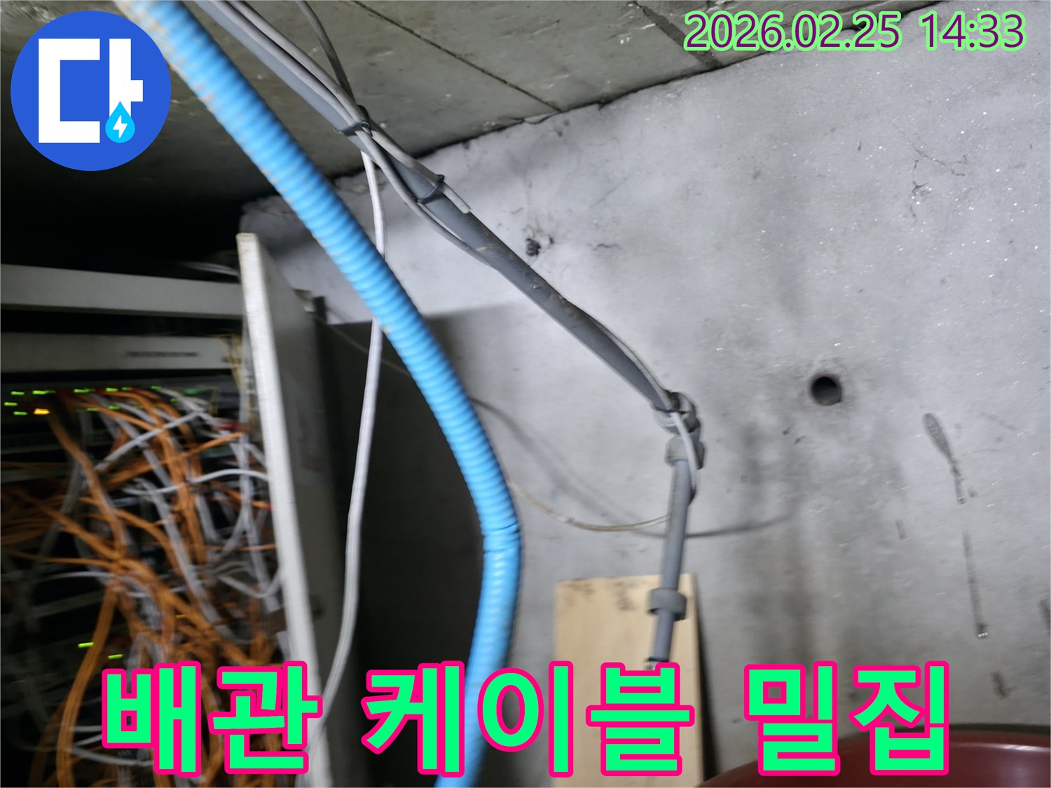 이 이미지는 누수 현장에서-콘크리트 벽면을 따라-복잡하게 얽힌 배관과 케이블의-설치 상태를 보여줍니다