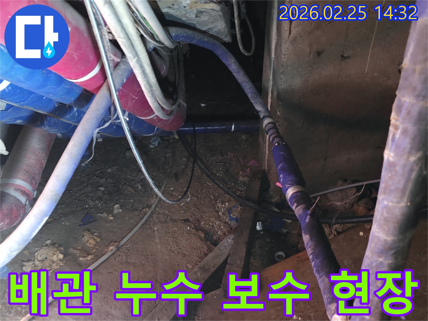 이 이미지는 흙이 드러난 공간에서 파손된 배관을-숙련된 기술자가-꼼꼼하게 수리하는 과정을 보여줍니다.