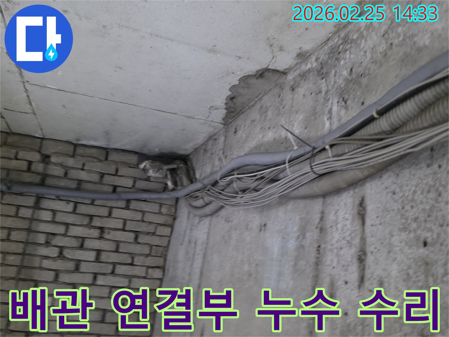 지하 벽면의-콘크리트와-벽돌 벽이 만나는-지점에서-발견된-오랜 누수로 인한-물자국과-배관 연결부의-손상 흔적