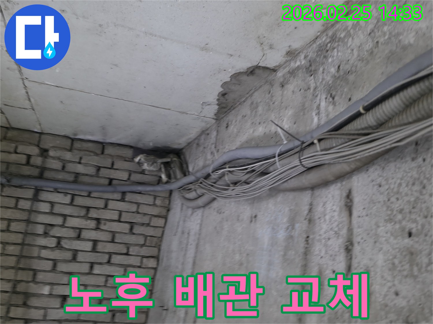 지하 벽면의-콘크리트와-벽돌 벽이 만나는-지점에서-발견된-오랜 누수로 인한-물자국과-주변의 복잡한 배관