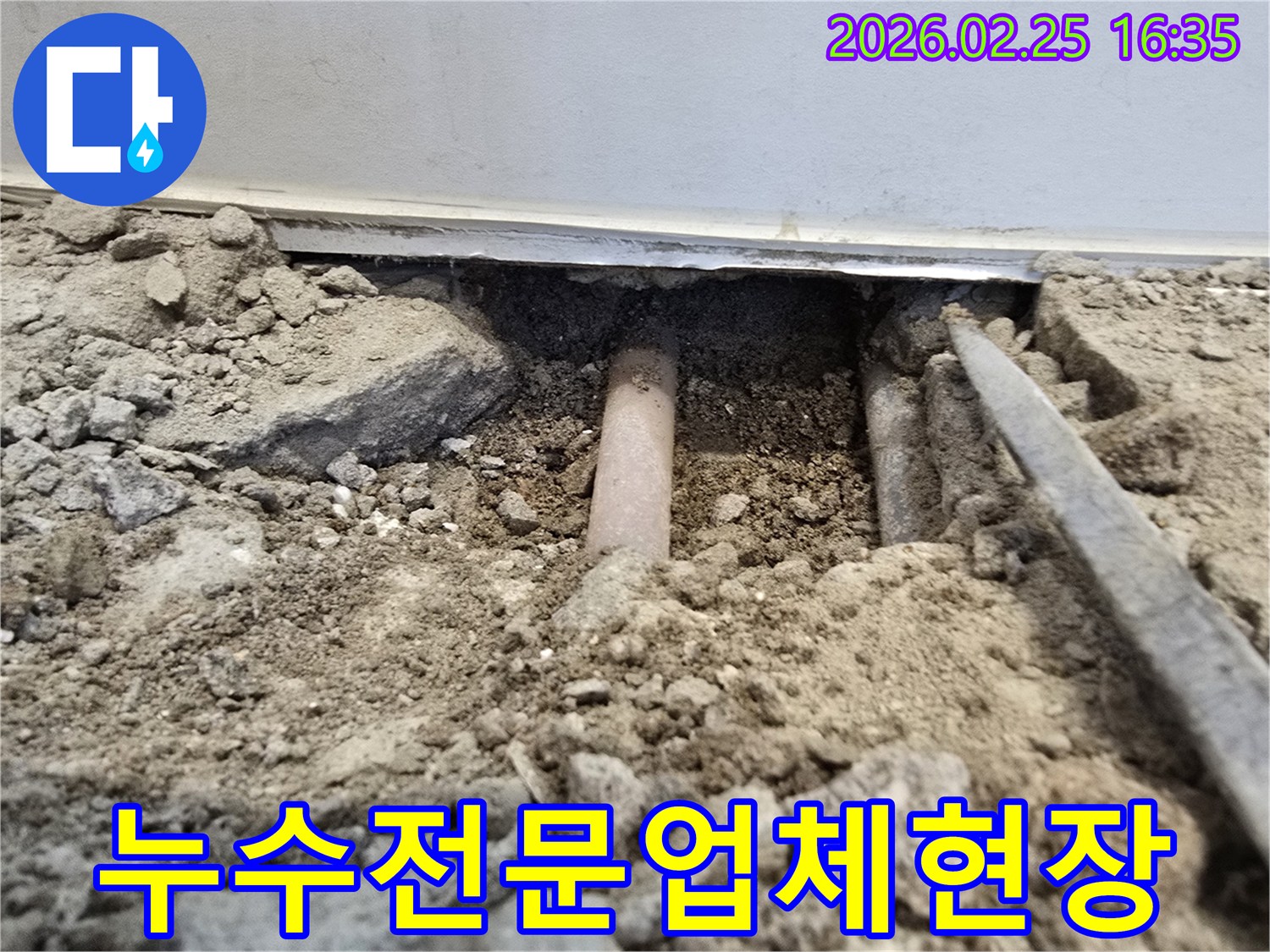 이-사진은-누수-전문-업체의-현장-작업으로-땅을-파내어-매립된-배관을-확인하는-모습을-담고-있습니다