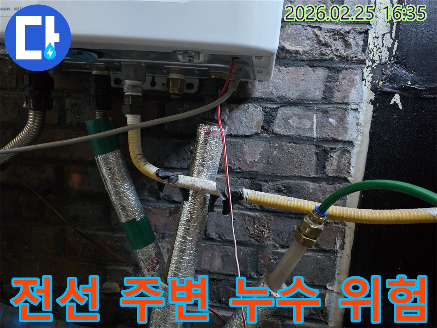 이 사진은-보일러 하단부의-배관들 사이로-지나가는-전선들을-보여주며-누수로 인한-전기적 위험성을-시사합니다.