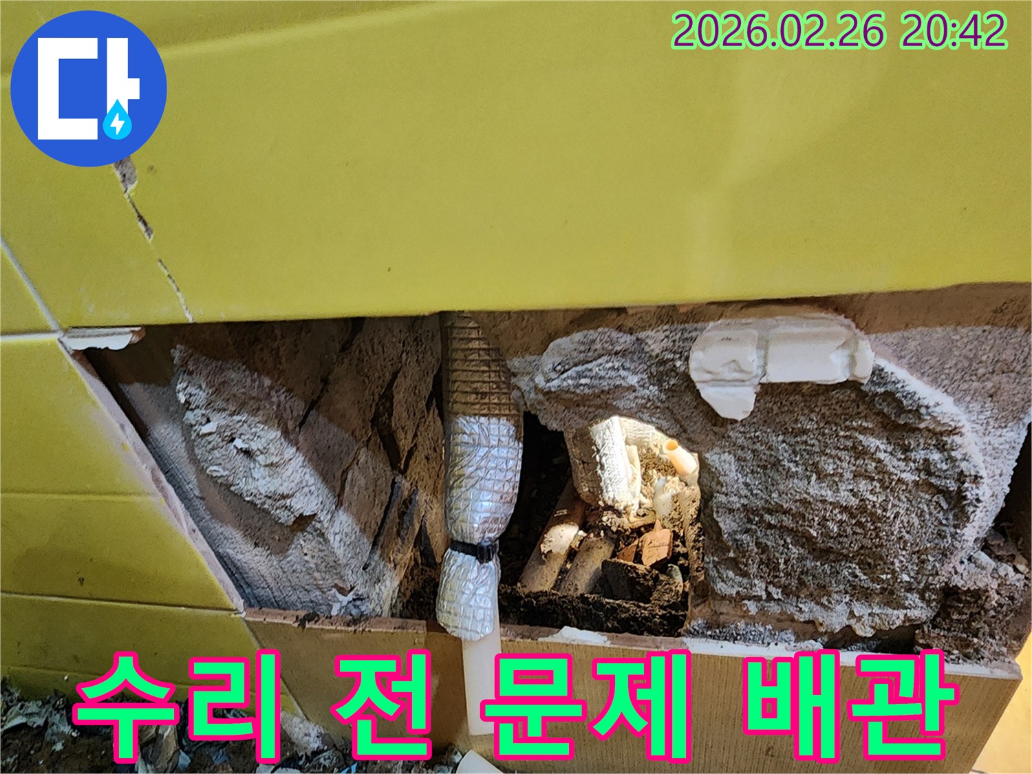 누수 수리 작업을 시작하기 전-벽체 내부의 문제 배관이-노출된 상태를 보여주는 사진입니다.