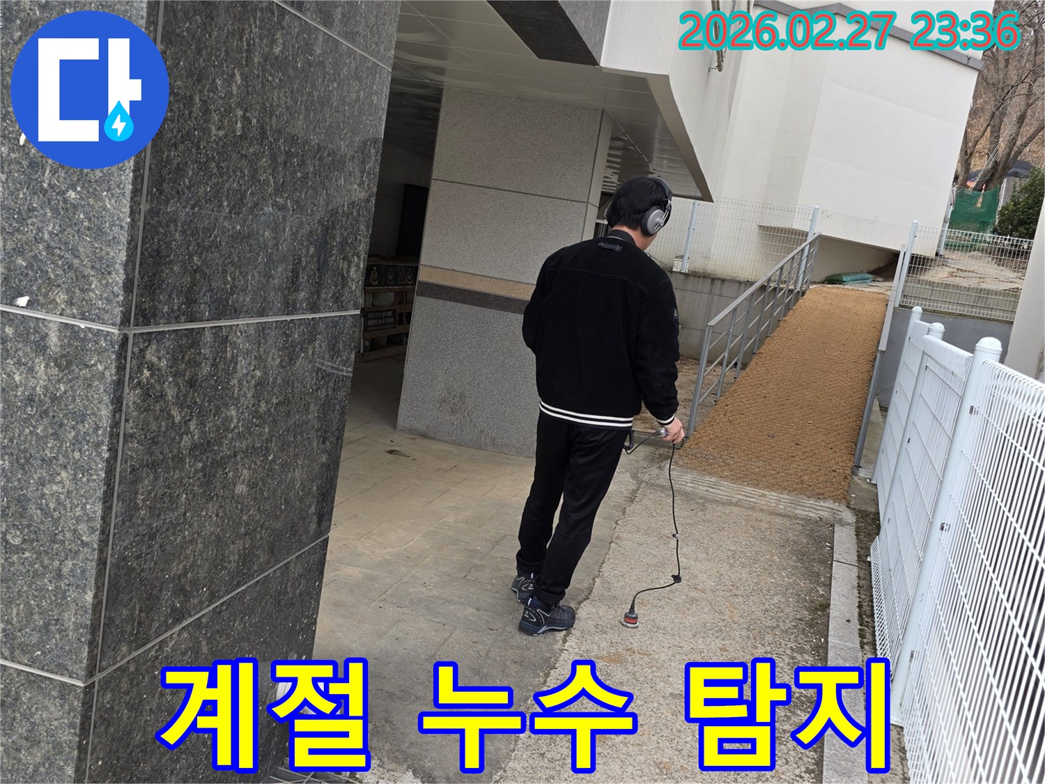 누수 엔지니어가-청음식 탐지 장비로-건물 외부의-계절 변화로 발생한-누수 지점을 정밀하게 탐지하는 모습