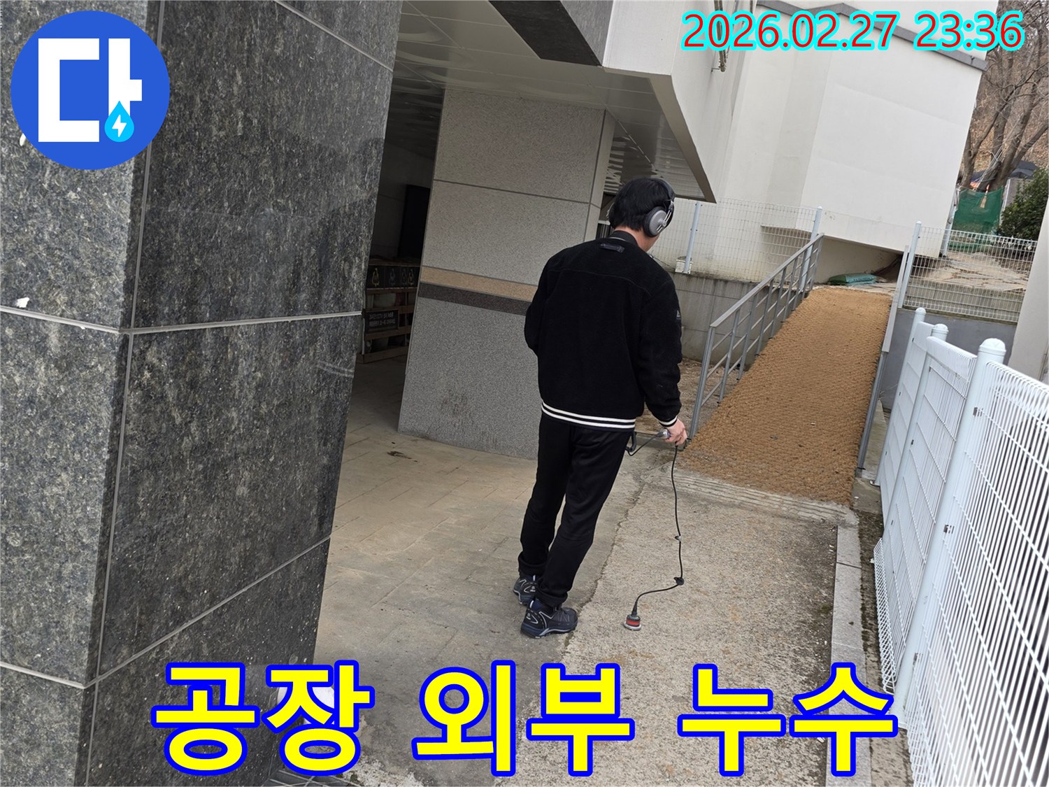 누수 엔지니어가-청음식 탐지기로-공장 건물 외부의-누수 지점을 신속하게 탐지하는 모습