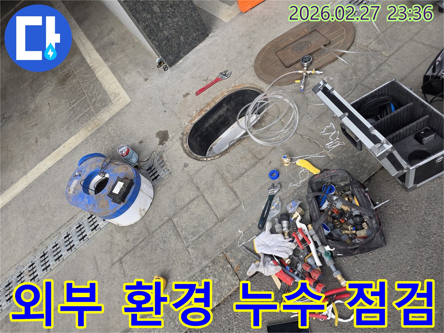 도로변-아래-매설된-지하-배관에서-발생하는-누수를-찾기-위해-외부-환경을-고려하여-탐지-장비가-준비된-현장-모습