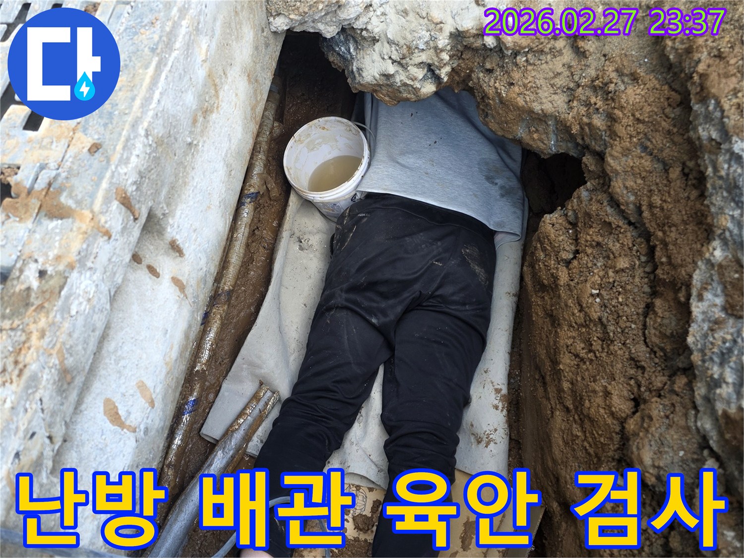 전문 엔지니어가 좁고 어두운 공간에서 난방 배관의 누수 지점을 꼼꼼하게 육안으로 검사하는 모습