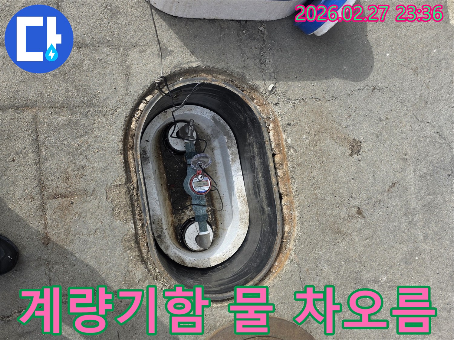 지하에 매설된 수도 계량기함 내부에-물이 차오른 상태를 보여주는 사진입니다.