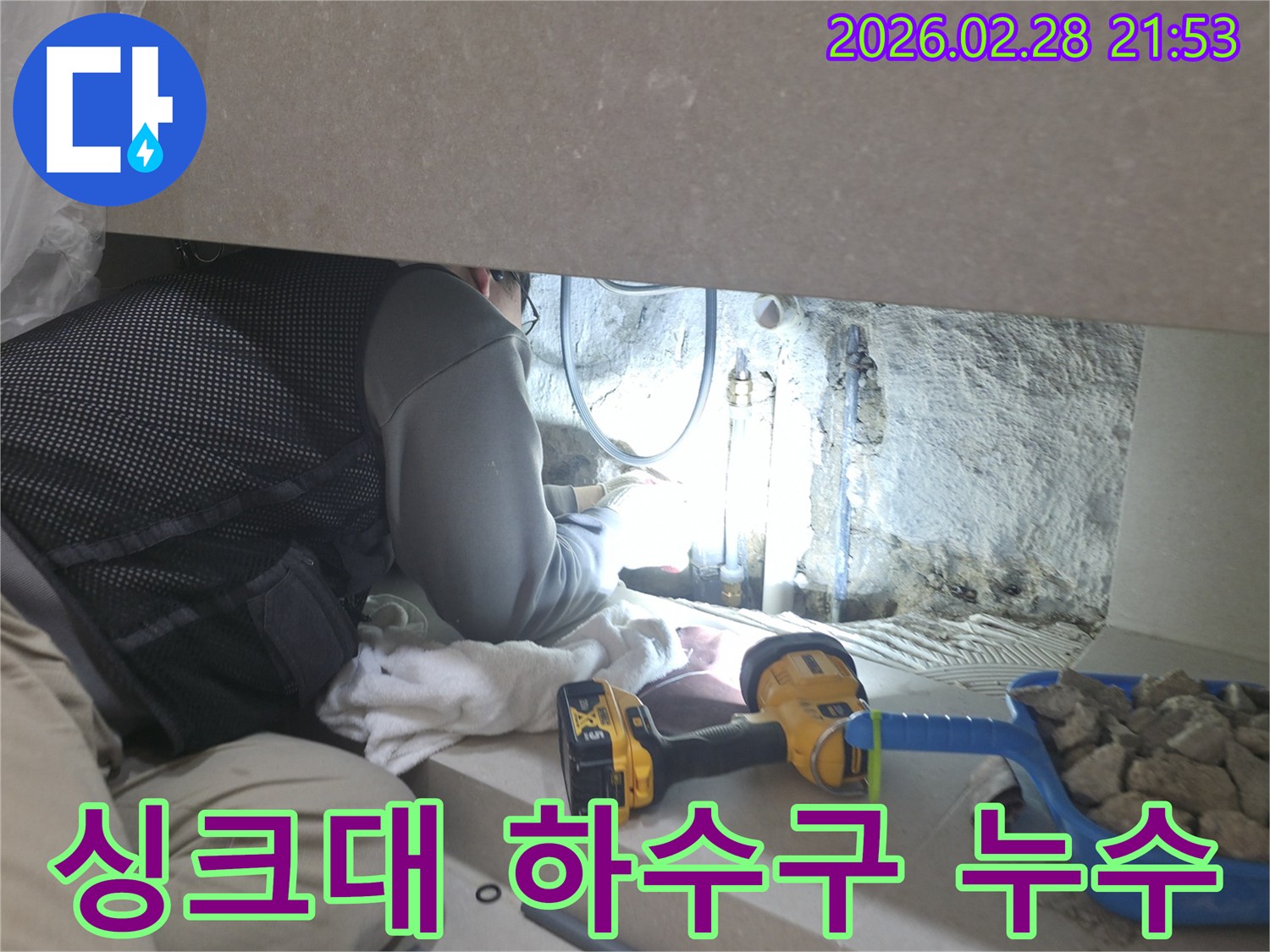 싱크대 하수구의-좁은 공간에서-누수 지점을-찾기 위해-집중하여-작업하는-전문 엔지니어의 모습입니다.