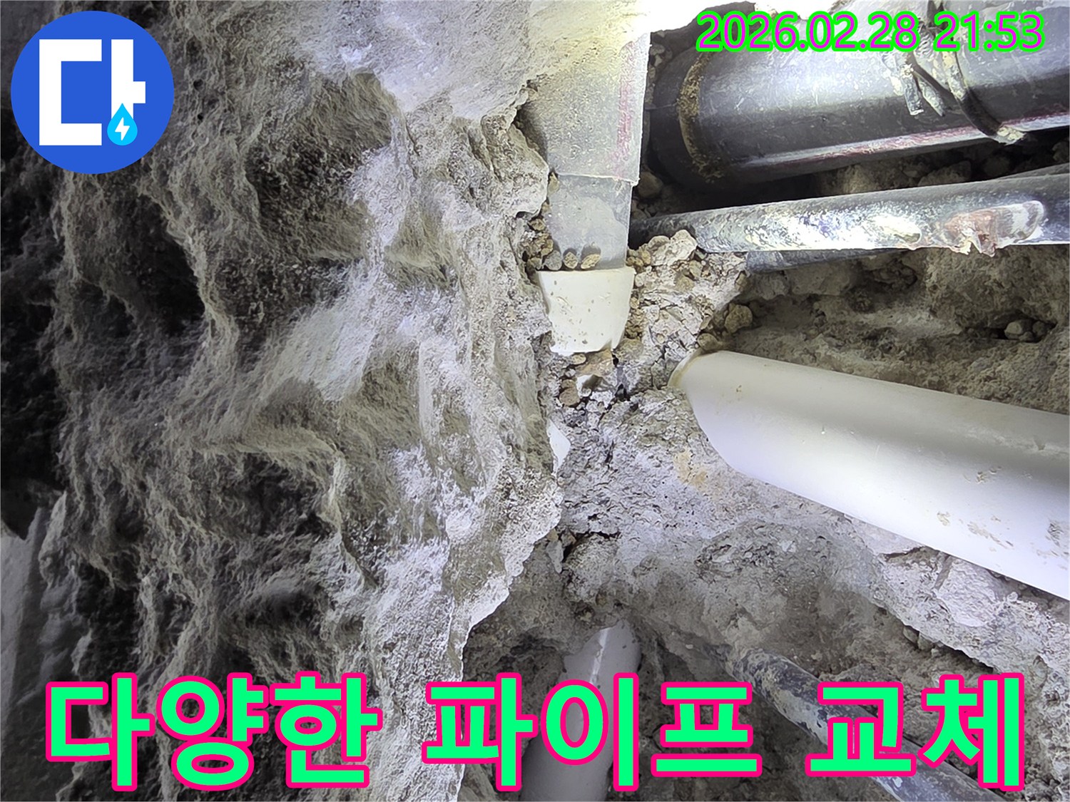 어두운 공간에서-흙과 자갈 속에 묻힌-다양한 배관들을-점검하고-교체를 준비하는 누수 전문가의 모습