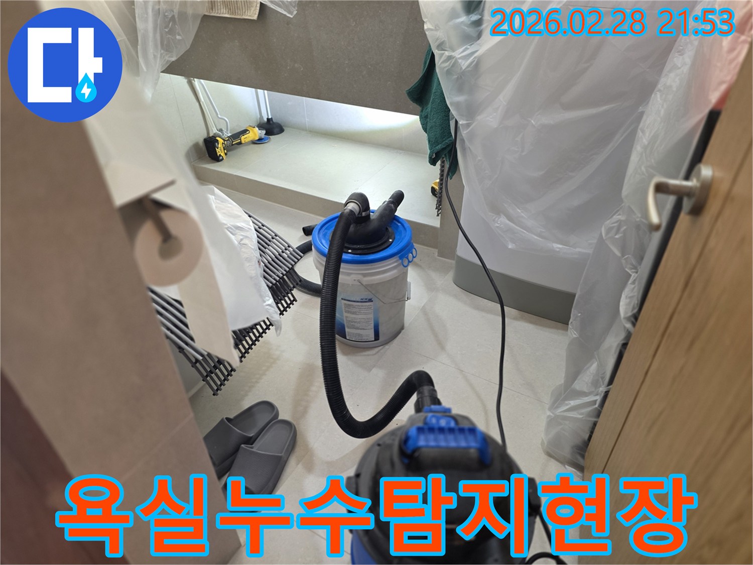 이 이미지는 욕실에서 발생한 누수를 정밀하게 탐지하기 위해-전문 장비를 설치하고-보양 작업을 진행하는 모습을 보여줍니다.