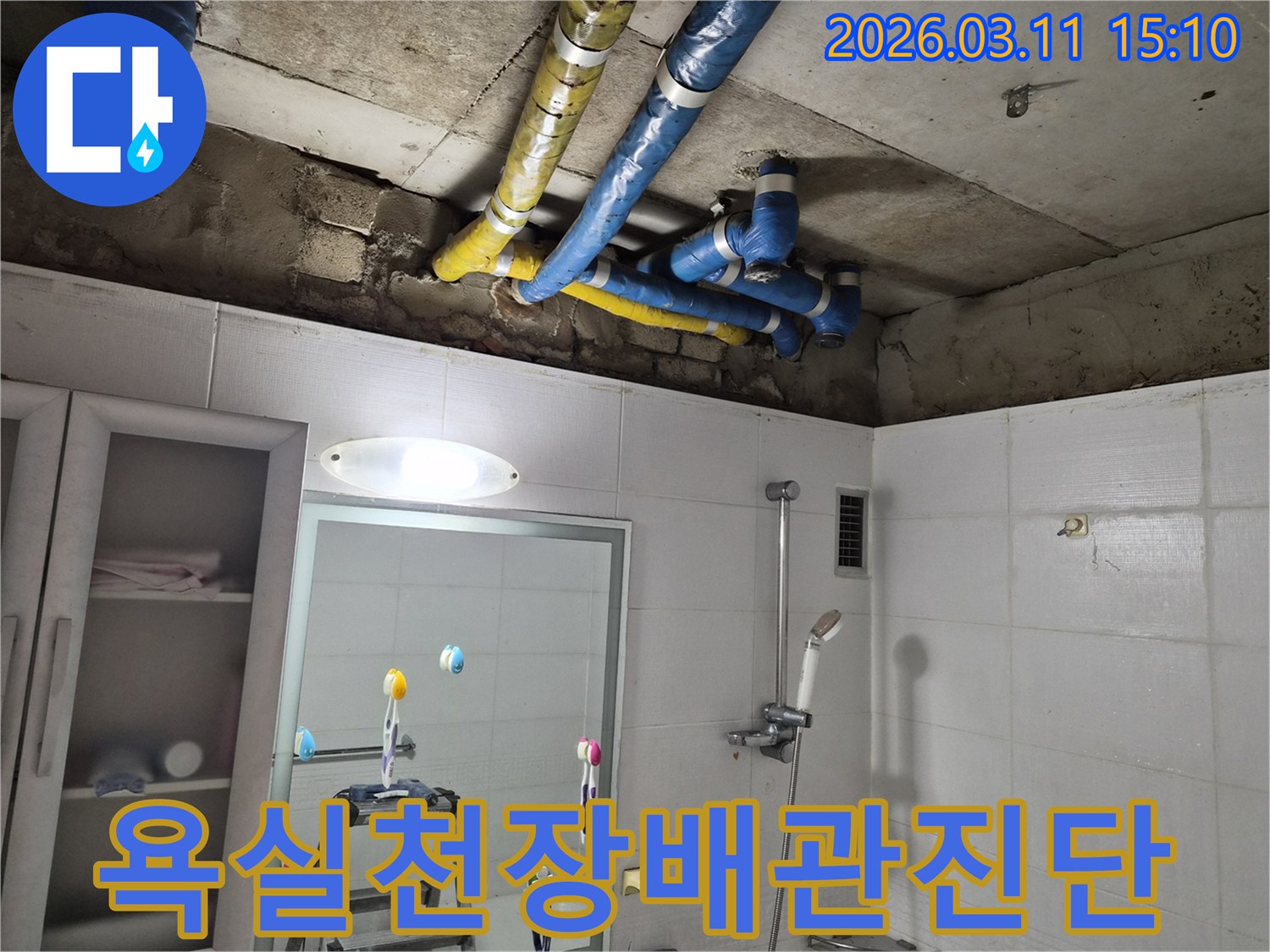 노원구-공릉동 욕실-천장에 노출된-파란색과 노란색-단열 배관을-정밀하게-점검하는-모습입니다
