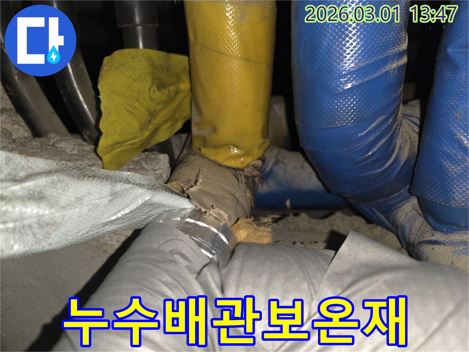 파란색과 노란색으로 구분된 배관의 보온재가 찢어져-내부 상태가 드러난 모습입니다.