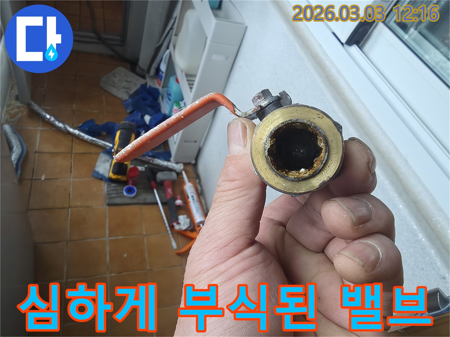 오래되어-내부가-심하게-부식된-수도-밸브를-손으로-들고-있는-모습입니다.