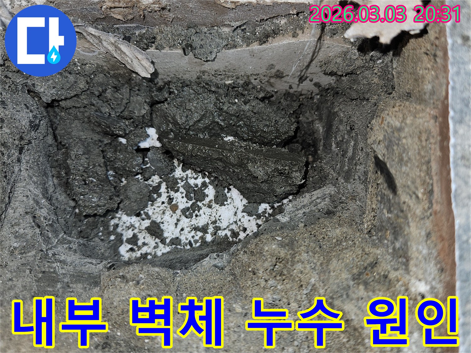 아파트 내부 벽체 누수 원인을 파악하기 위해 벽면을 개방하고-젖은 시멘트와 물이 스며든 흔적을 면밀히 관찰하고 있습니다.