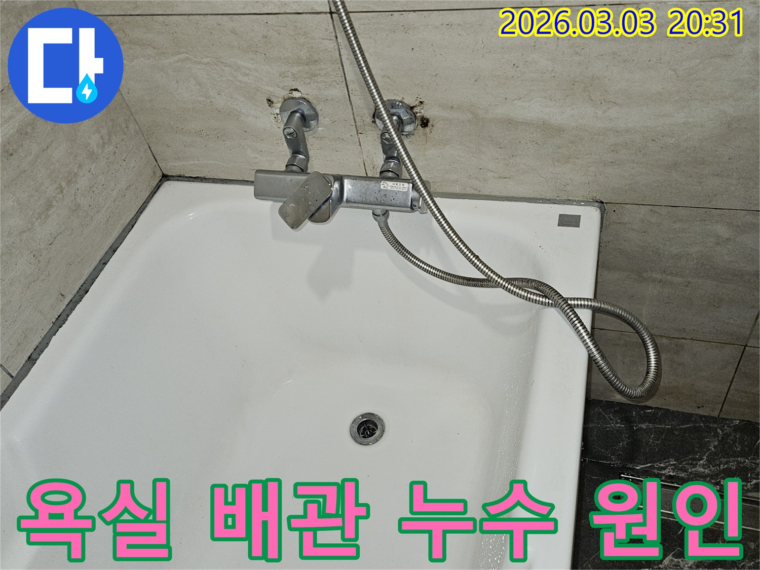 오래된 욕실에서-누수 흔적이 발견되어-샤워기 수전과-벽면 배관의-연결 상태를-확인하는 장면입니다