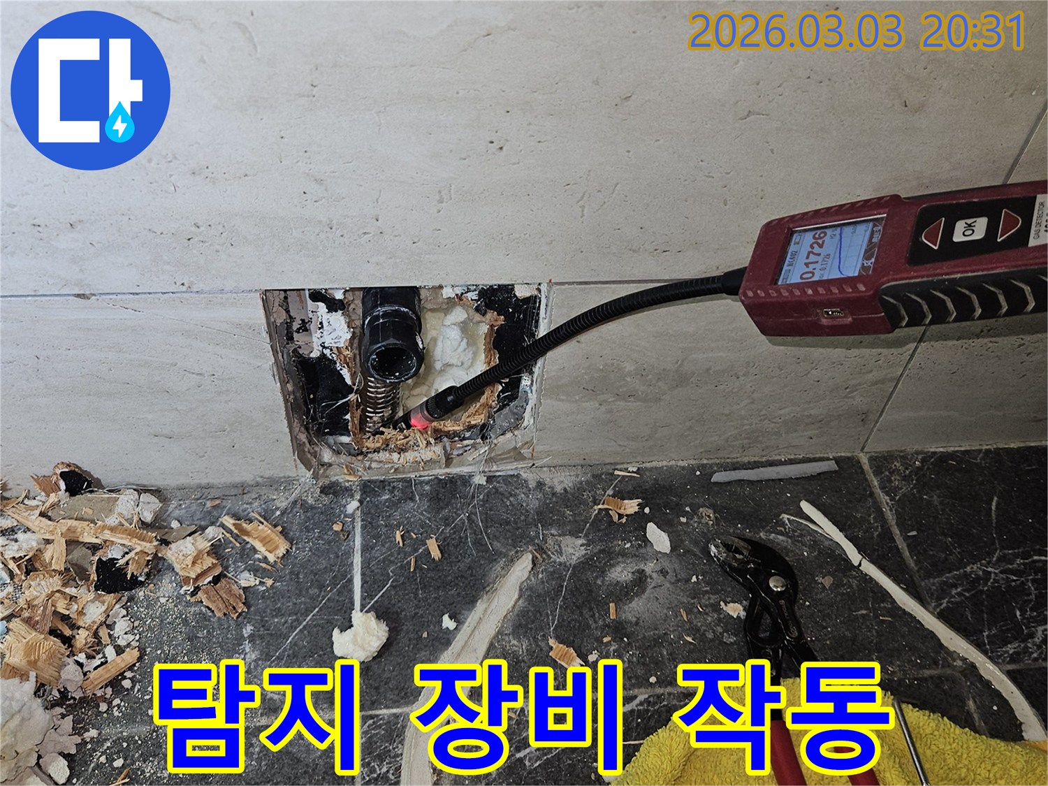 전문가가-누수 탐지-장비를-작동시켜-벽 내부의-누수-지점을-찾아내는-모습