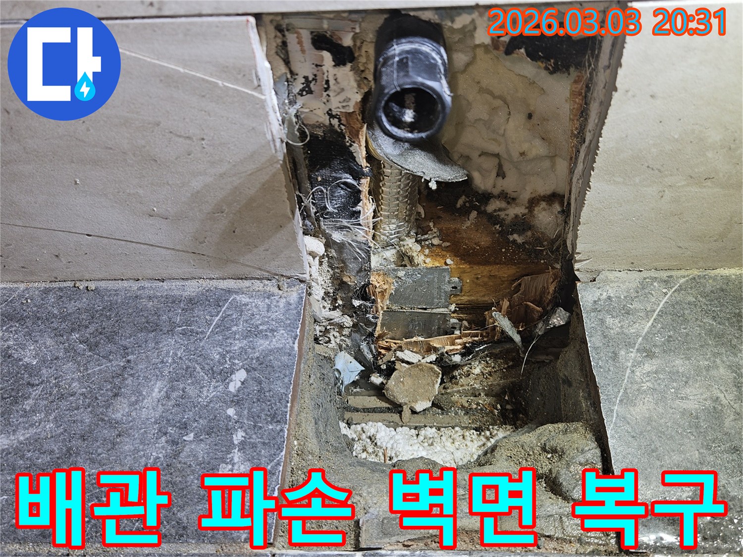 주택 벽면의 타일을 뜯어내고 누수 원인인 낡은 배관을 찾아낸 후-손상된 벽면을 복구하기 위한 준비가 진행되는 공사 현장