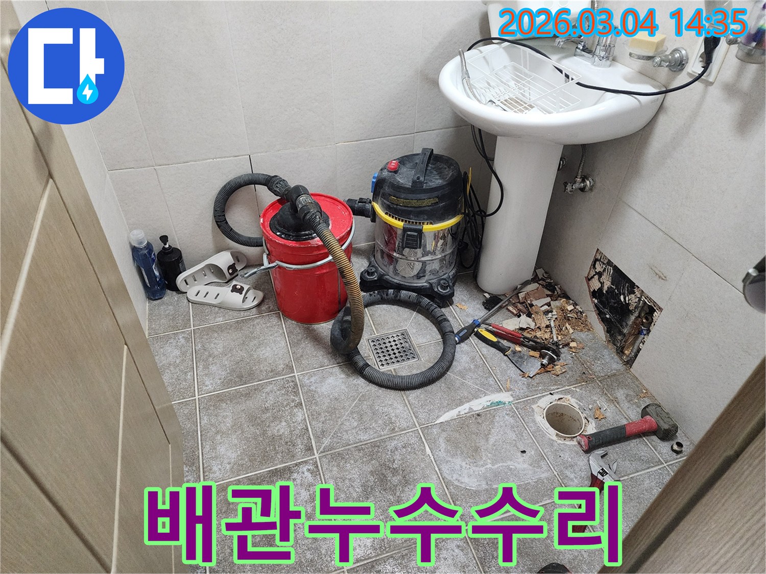 누수된 물을-제거하고-배관 압력을-테스트하기 위해-설치된-전문 장비들이-욕실 바닥에-놓여 있습니다