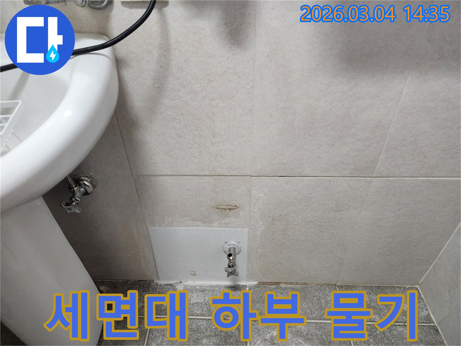 세면대 하부 벽면에-물기가 스며들어 생긴-누수 흔적을 보여주는 사진