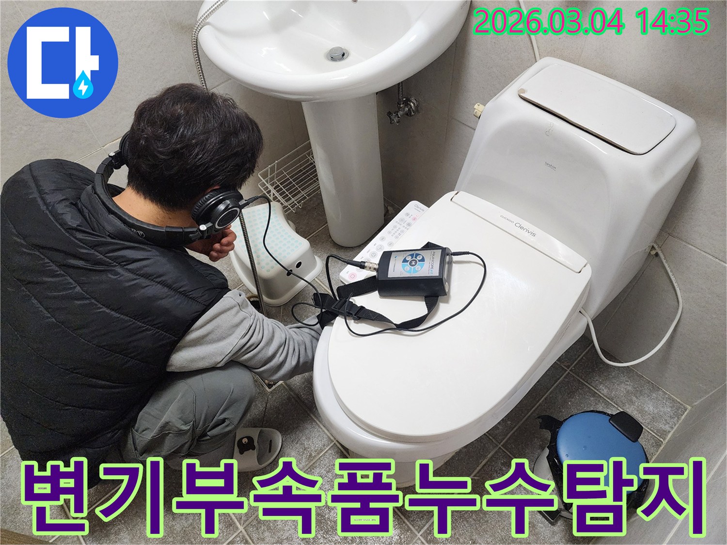 엔지니어가-헤드폰을-착용하고-변기-부속품-주변의-누수-여부를-청음식-탐지기로-정밀하게-진단하는-모습