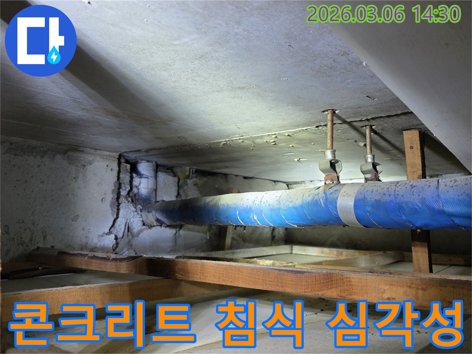 오래된 지하 공간의-파란색 배관 주변-심하게 침식된 콘크리트 벽면을-보여주는 누수 현장 사진