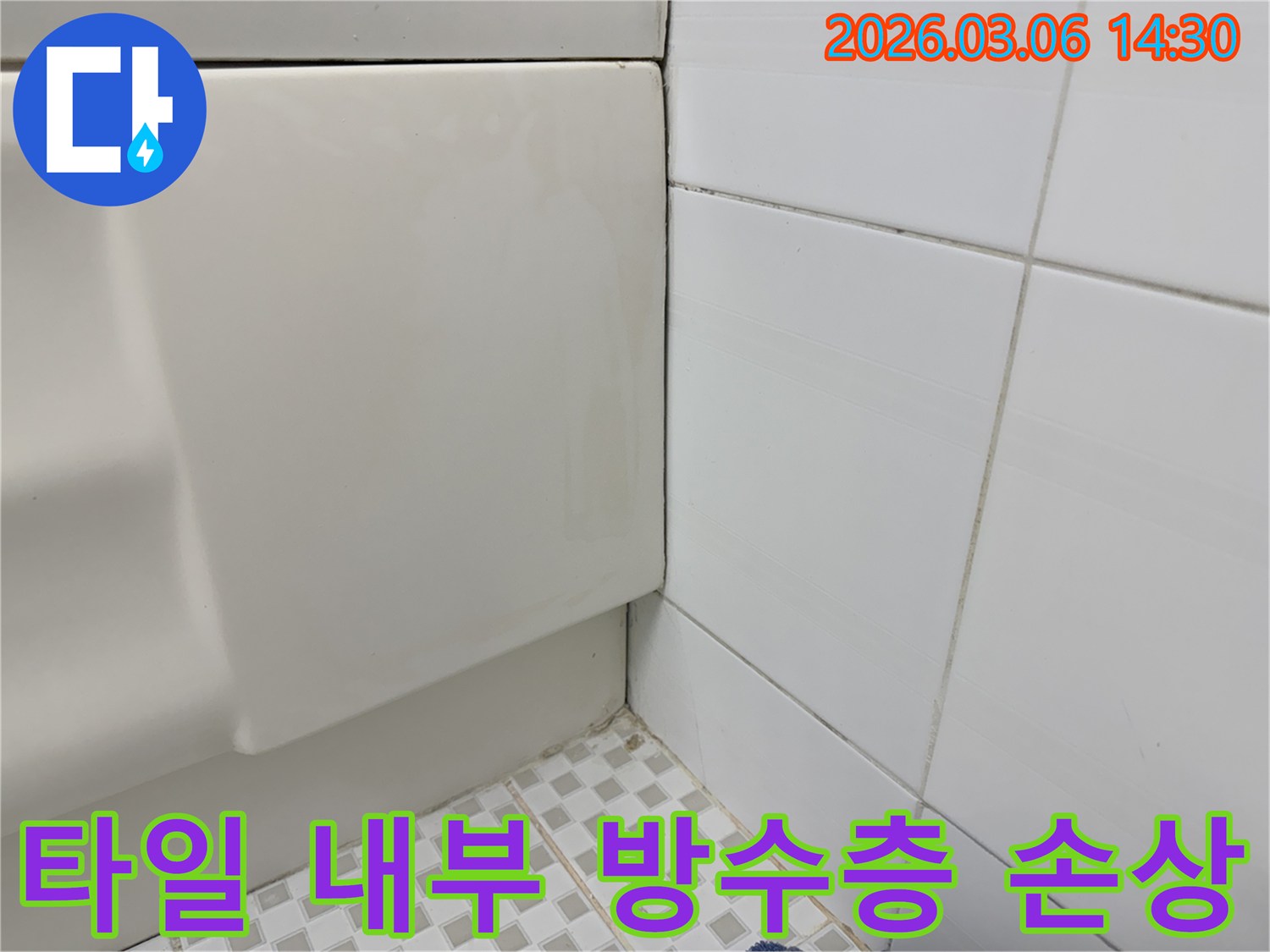 욕실-벽면-타일의-하단부와-바닥-타일-경계면에서-발견된-오염과-습기로-타일-내부-방수층-손상이-의심되는-상황을-보여주는-이미지