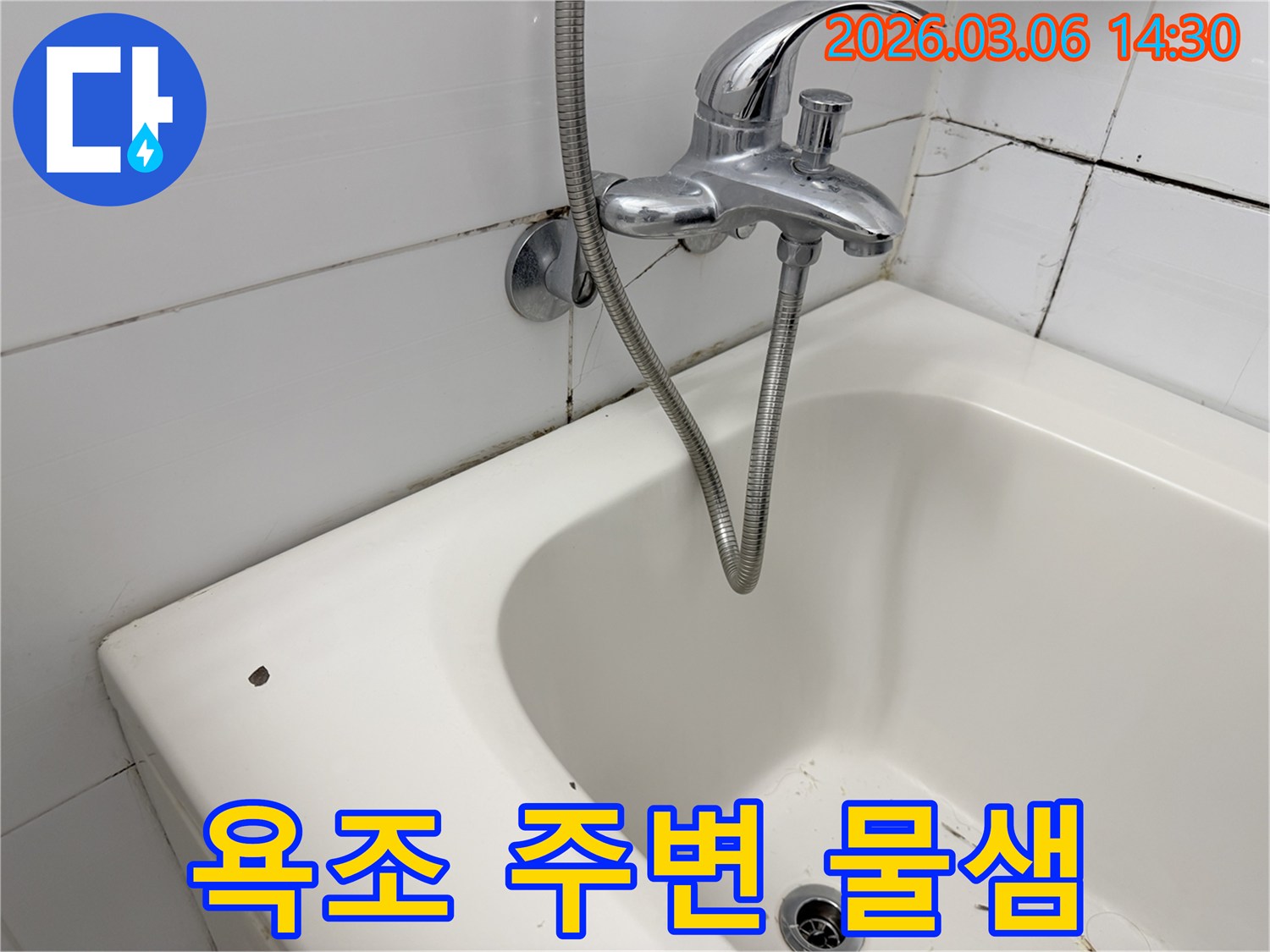 욕실의 흰색 욕조와-벽면 타일의 균열-그리고 수도꼭지 샤워기 세트가 보입니다.