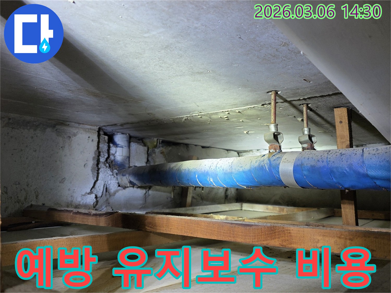 지하 공간의 파란색 배관과-손상된 콘크리트 벽면을-누수 엔지니어가-예방적 유지보수의 중요성을-설명하며 점검하는 모습